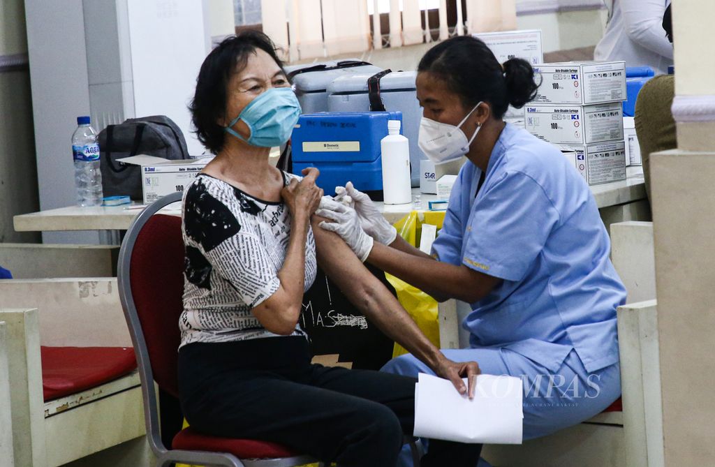 Warga lanjut usia menerima suntikan vaksin Covid-19 ketiga dalam kegiatan vaksinasi massal Covid-19 penguat bagi warga lansia di Puskesmas Kebon Jeruk, Jakarta Barat, Jumat (14/1/2022). Vaksin penguat diberikan kepada warga lansia yang telah mendapatkan vaksinasi dosis pertama dan kedua.