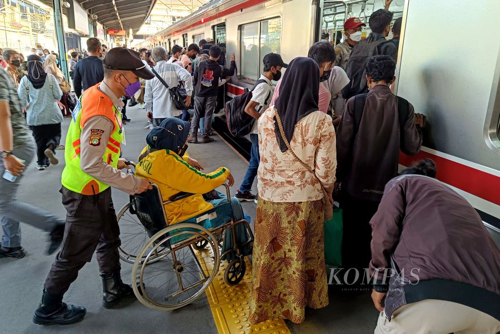 Petugas membantu penumpang naik ke gerbong KRL Commuterline di Stasiun Tanah Abang, Jakarta, Jumat (8/7/2022). KAI Commuter menambah perjalanan KRL Commuter Line setiap hari sejalan dengan kenaikan pengguna. Jumlah perjalanan KRL ditambah menjadi 1.081 perjalanan per hari dari awalnya 1.054 perjalanan per hari mulai Kamis (7/7/2022).