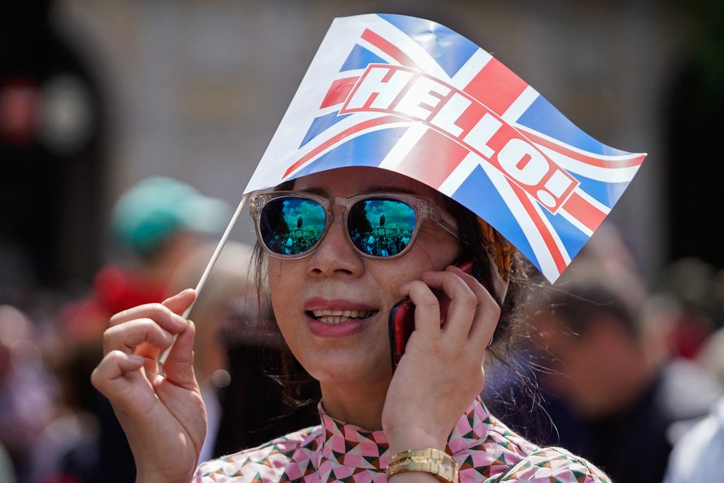 Seorang warga memegang bendera Union kecil menjelang perayaan Platinum Jubilee Ratu Elizabeth II di London (2/6/2022). Selama 70 tahun, Ratu Elizabeth II telah memimpin kerajaan Inggris sejak ia berusia 26 tahun pada 1952. Pada 2015 lalu, Ratu Elizabeth II sudah mengalahkan neneknya, Ratu Victoria, yang dulu pernah menjadi ratu Inggris selama 64 tahun.