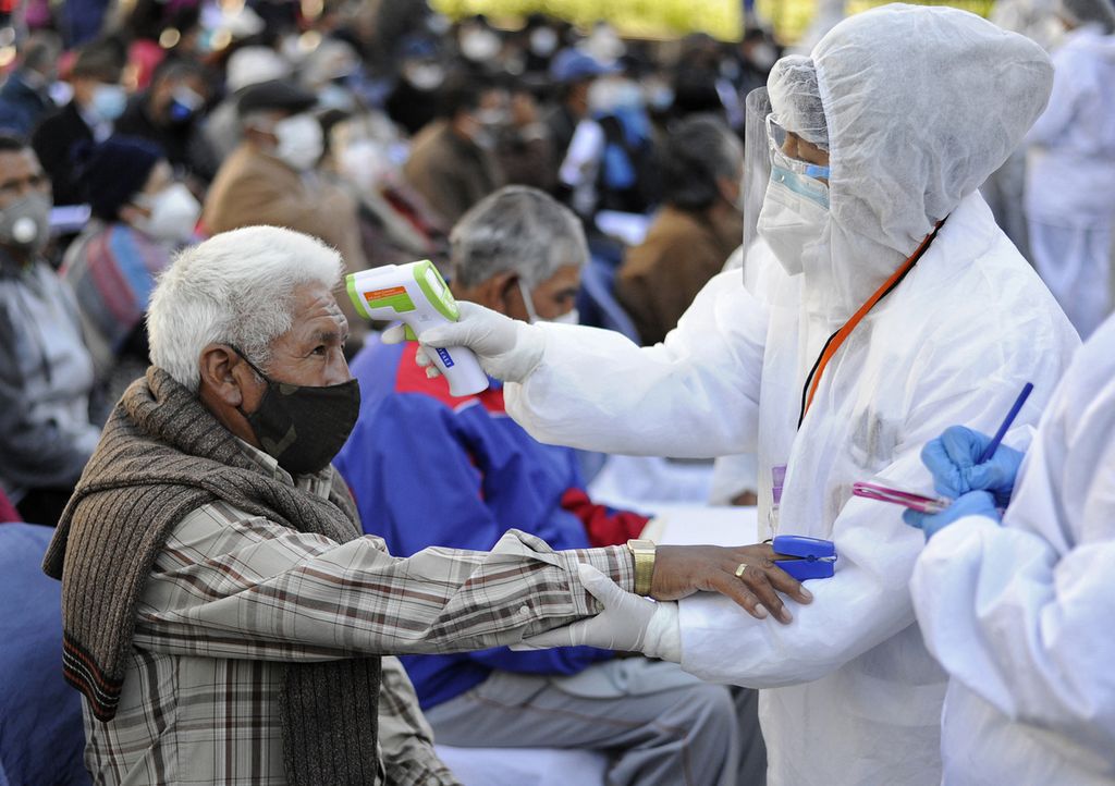 Seorang lansia Bolivia diperiksa suhunya sebelum dia dapat mendaftar untuk mendapatkan dosis pertama vaksin Sputnik V Rusia untuk melawan virus korona di La Paz, Bolivia, (27/4/2021). 
