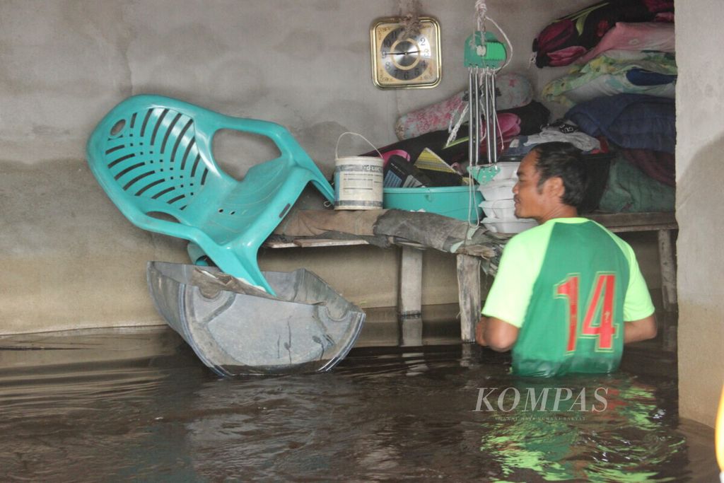 Warga Sintang, Kalimantan Barat, yang masih bertahan di dalam rumah meskipun dikepung banjir. Mereka memodifikasi drum untuk alat transportasi, Sabtu (30/10/2021). 