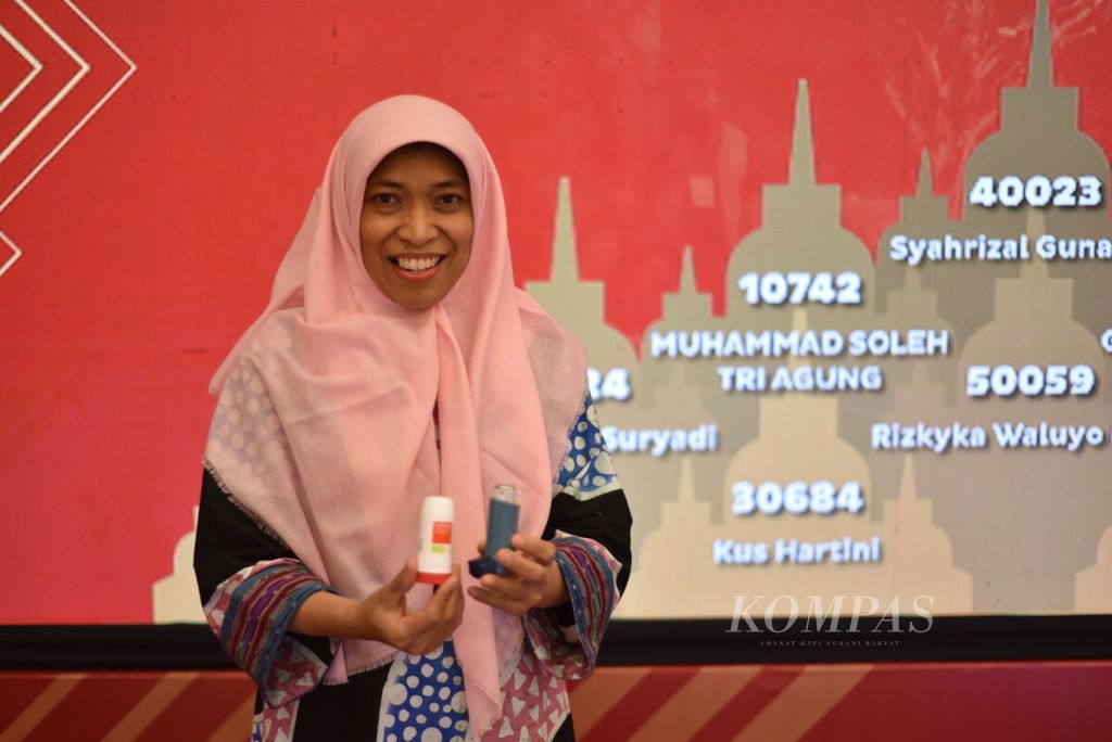 Peserta lomba 10K Borobudur Marathon 2018 asal Jakarta, Kus Hartini, menunjukkan obat semprot inhaler untuk asma seusai mengambil nomor perlombaan Borobudur Marathon 2018 di Magelang, Jawa Tengah, Jumat (16/11/2018).