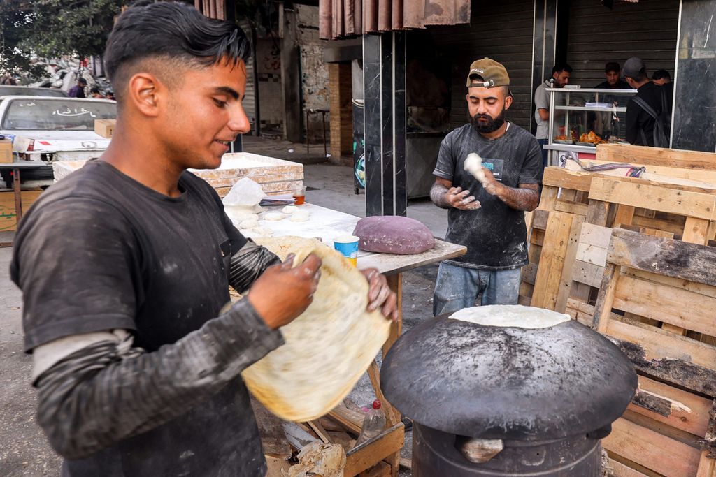 Pekerja warung makan menyiapkan roti di dekat Rafah, Gaza, 23 April 2024. Puluhan ribu warga Palestina tewas akibat serangan Israel di Gaza. 