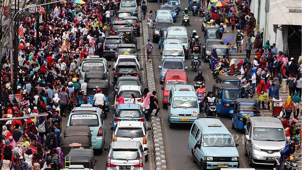 Pedagang kaki lima (PKL)  dan pembeli memadati trotoar di Jalan Jatibaru, Tanah Abang, Jakarta Pusat, Minggu (14/5). Hal ini menyebabkan kemacetan di wilayah tersebut.