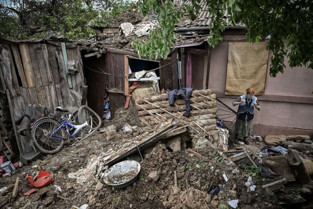 Seorang wanita lanjut usia berdiri di area rumahnya yang rusak parah setelah terkena rudal di kota Bakhmut di wilayah Donbas, Ukrania timur, 22 Mei 2022, di tengah perang Rusia dan Ukraina. 