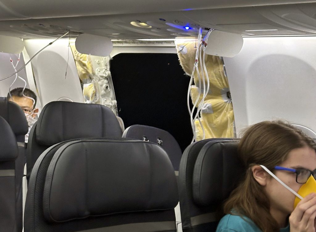 Para penumpang berada di dekat lubang badan pesawat (<i>fuselage</i>) Alaska Airlines Boeing 737 Max 9 dengan nomor penerbangan 1282 yang terpaksa kembali ke Bandara Internasional Portland, AS, 5 Januari 2024. 
