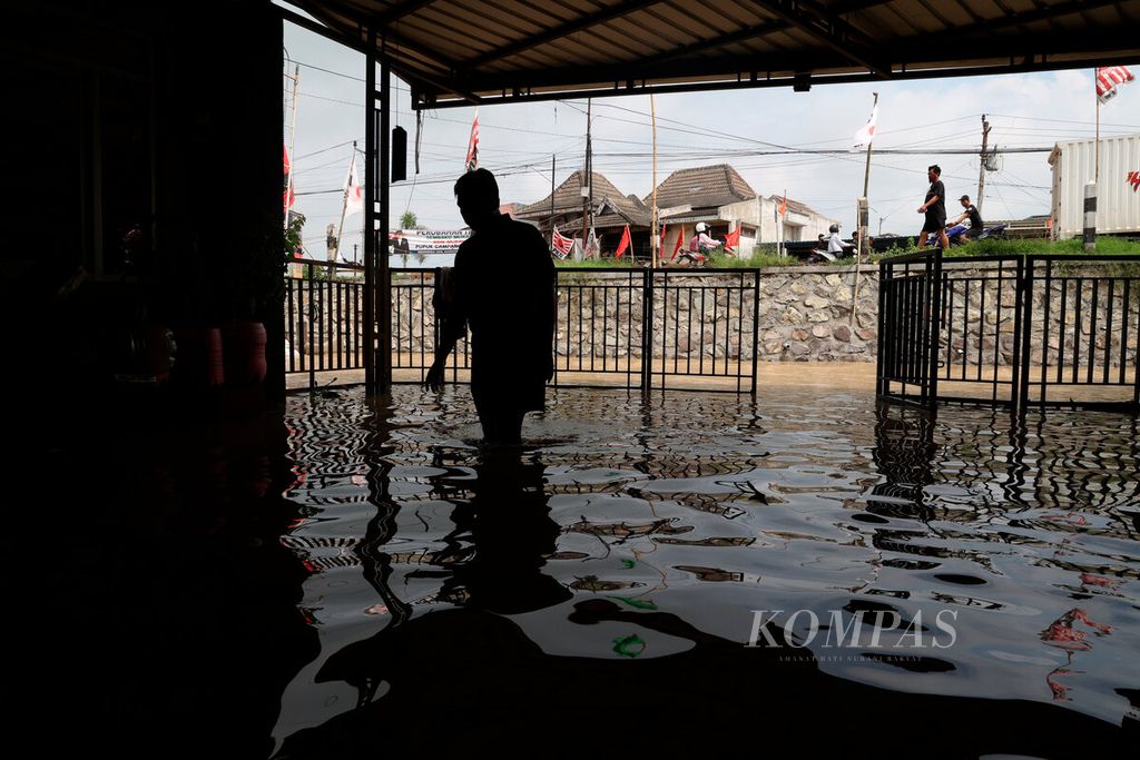 Warga berada di teras rumahnya yang terendam banjir di Kecamatan Gubug, Kabupaten Grobogan, Jawa Tengah, Selasa (6/2/2024).