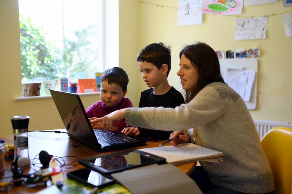 Leo (C), aged 6, and Espen, aged 3, are assisted by their mother Moira as they navigate online learning resources provided by their infant school in the village of Marsden, near Huddersfield, northern England on March 23, 2020 on the first school day since the nationwide closure of almost all schools except for the children of \'key workers\', amidst the novel coronavirus COVID-19 pandemic. - Families across the UK were coming to grips with homeschooling and online resources after the government closed schools to almost all children as a measure to combat the spread of the novel coronavirus. (Photo by OLI SCARFF / AFP)