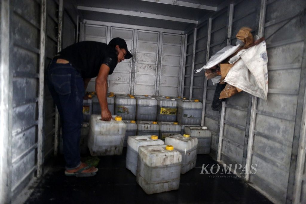 Karyawan agen penyalur memasukkan jeriken berisi minyak goreng curah ke dalam truk di Tanah Abang, Jakarta, Selasa (7/2/2023). 