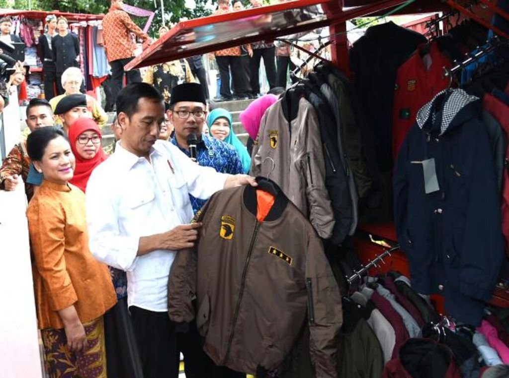 Presiden Joko Widodo didampingi Ridwan Kamil melihat produk yang ditawarkan pedagang kaki lima di Teras Cihampelas, Kota Bandung, Jawa Barat.