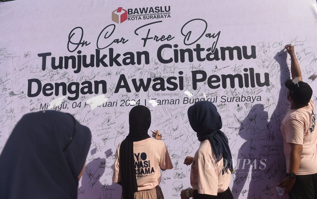 Sukarelawan membubuhkan tanda tangan dukungan saat acara Bawaslu Surabaya on Car Free Day bertema Tunjukkan Cintamu dengan Awasi Pemilu di Taman Bungkul, Surabaya, Jatim, Minggu (4/2/2024). 