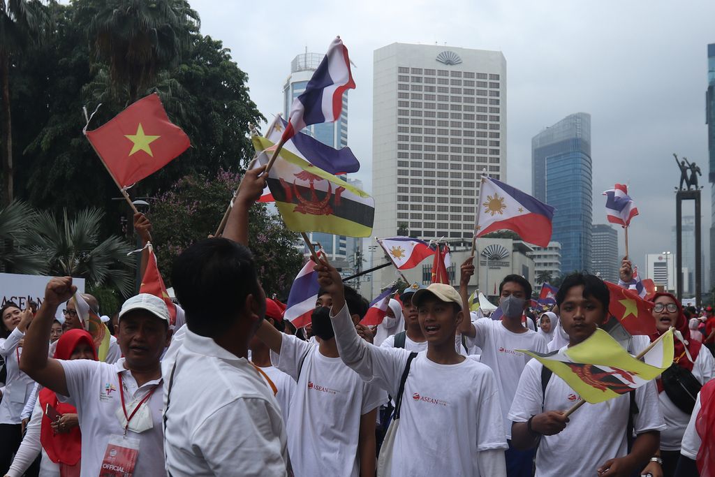 Para pelajar berjalan sembari mengibarkan bendera negara-negara anggota ASEAN dalam parade Kick Off Keketuaan ASEAN Indonesia 2023 di Jalan MH Thamrin, Jakarta, Minggu (29/1/2023). Presiden Joko Widodo resmi membuka keketuaan Indonesia di ASEAN 2023. Acara tersebut menjadi pembuka dari rangkaian kegiatan Konferensi Tingkat Tinggi (KTT) ASEAN pada Mei 2023 di Labuan Bajo dan KTT ASEAN Plus di Jakarta pada September 2023. 