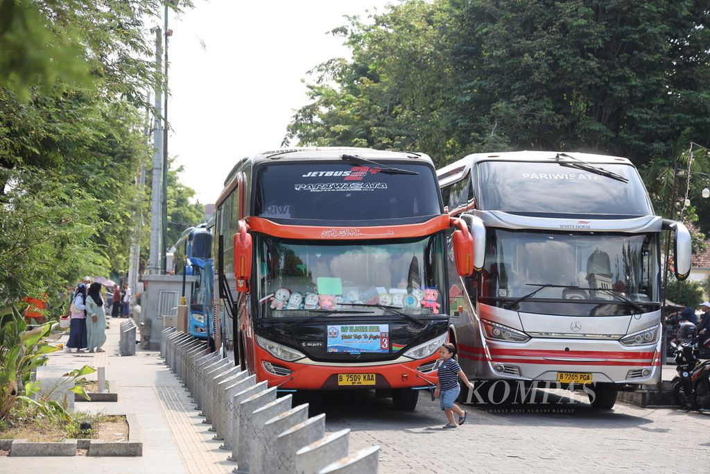 Sejumlah bus pariwisata diparkir kawasan Titik Nol, Yogyakarta, Selasa (26/12/2023). Melonjaknya kunjungan wisatawan di Yogyakarta selama masa liburan akhir tahun membawa angin segar bagi para pelaku industri pariwisata di kota itu.  