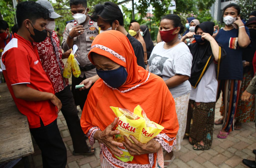 Seorang warga membawa minyak goreng yang dibeli dalam operasi pasar yang berlangsung di Kelurahan Pinang, Kecamatan Pinang, Kota Tangerang, Banten, Senin (10/1/2022). Operasi pasar minyak goreng murah tersebut diserbu warga.