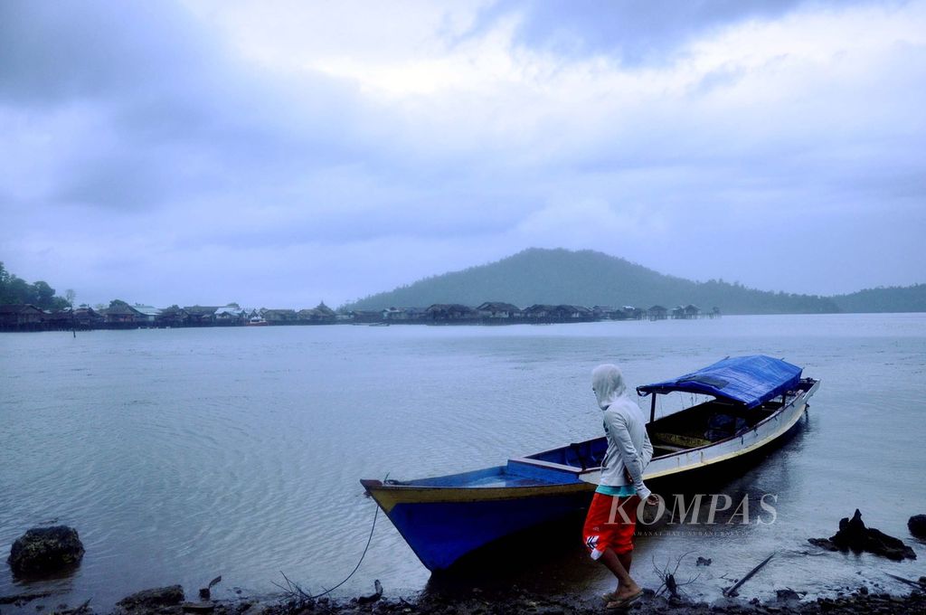 Seorang nelayan di Desa Kolo Bawah memperhatikan perahunya yang tertambat di pesisir. Saat itu, pasca-insiden Tiaka pada akhir Agustus 2011, nelayan masih belum berani melaut.