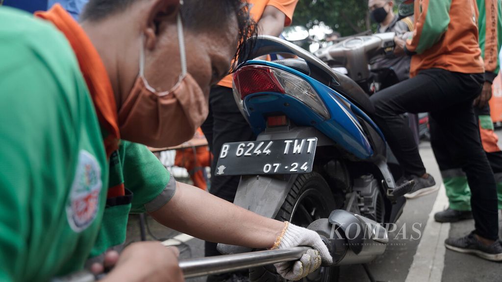 Aktivitas petugas Suku Dinas Lingkungan Hidup dalam uji emisi gratis di Jalan Pemuda, Jakarta Timur, Rabu (6/1/2021). 