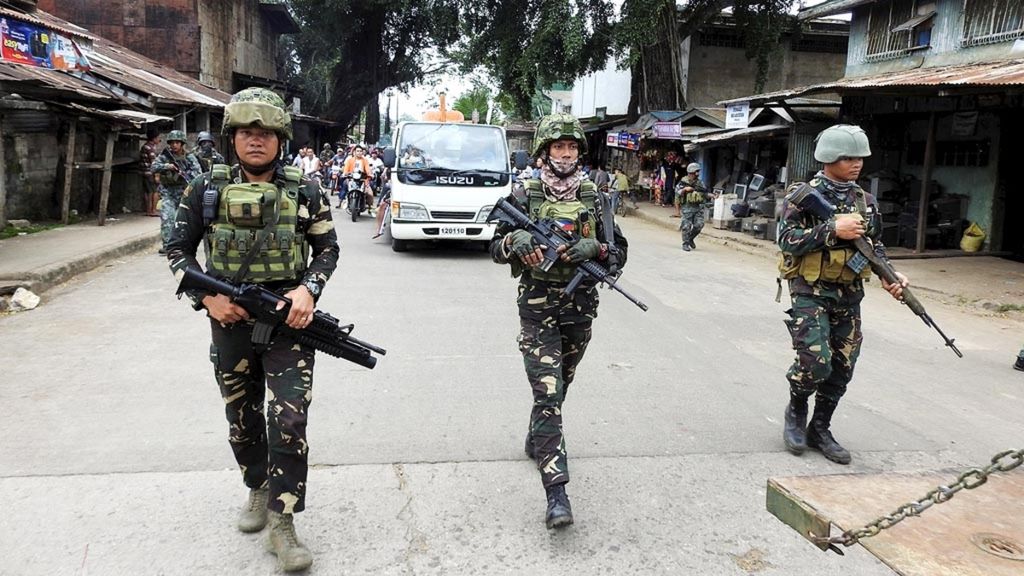 Tentara Filipina mengawal sebuah mobil jenazah saat pemakaman seorang korban yang tewas dalam pengeboman Katedral Bunda Maria dari Gunung Karmel, Jolo, Mindanao Selatan, 27 Januari 2019. Penyelidik menduga serangan itu didalangi jaringan kelompok militan Abu Sayyaf.