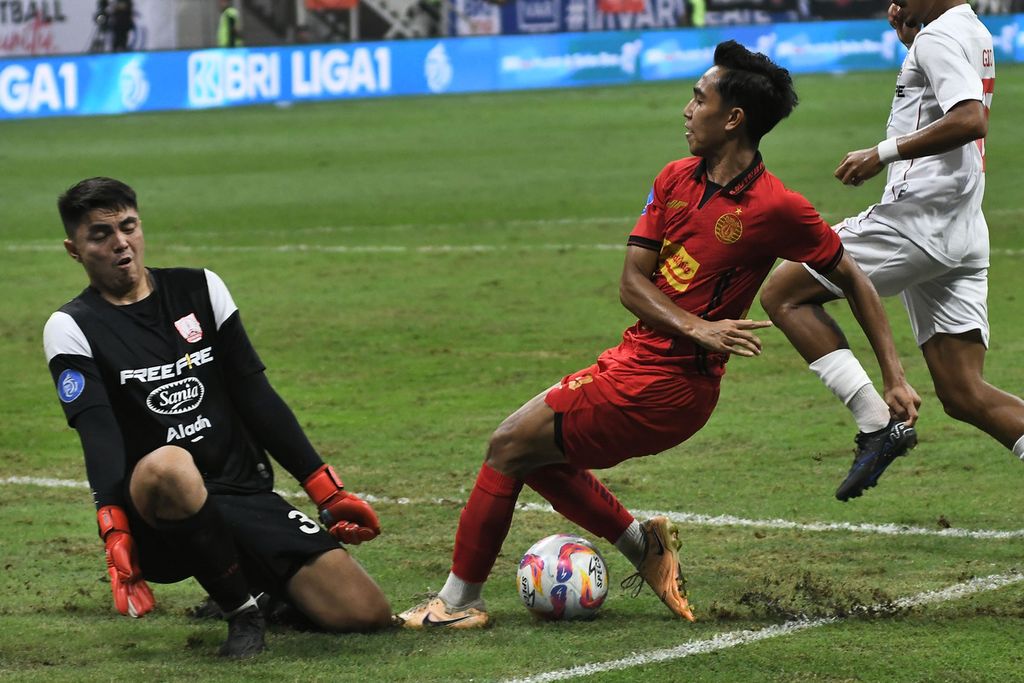 Pemain Persija Jakarta, Rayhan Hannan (kanan), melakukan tendangan yang ditepis penjaga gawang Persis Solo, Gianluca Claudio, pada lanjutan Liga 1 di JIS, Jakarta Utara, Sabtu (24/8/2024). Persija menang dengan skor 2-1.