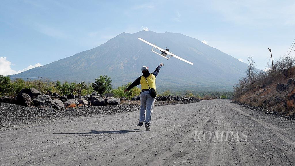 Petugas dari Tim Drone BNPB melepaskan drone tawon dari Desa Kubu, Kecamatan Kubu, Kabupaten Karangasem, Bali, Rabu (11/10). Penggunaan drone dilakukan untuk mengambil data visual  kondisi kawah serta areal di sekitar puncak dari Gunung Agung.