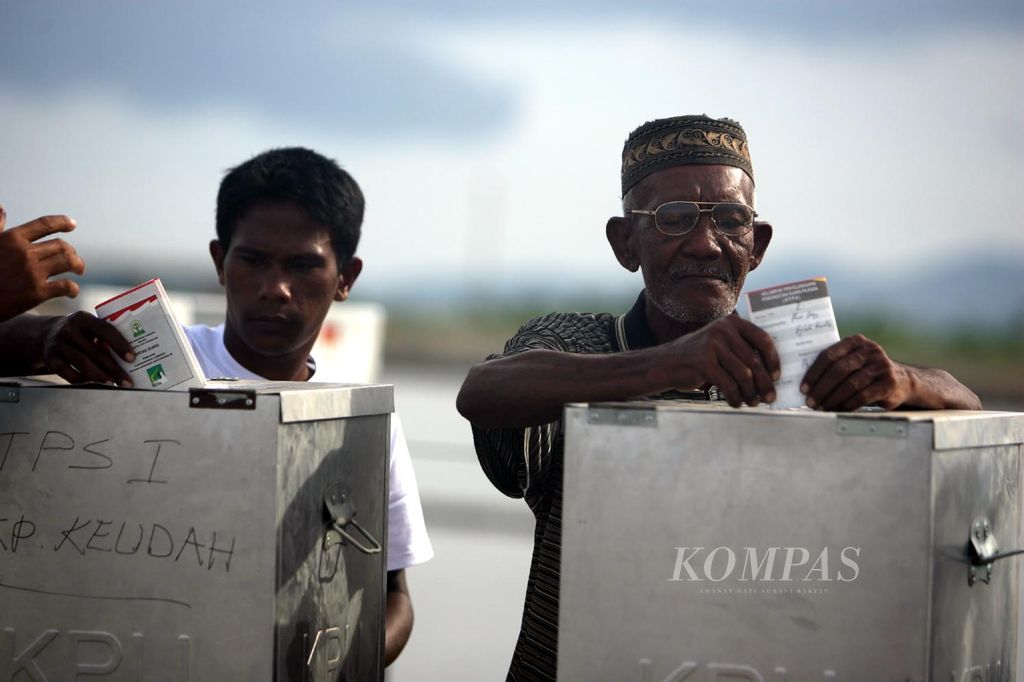 Dua warga Aluenaga menggunakan hak pilihnya untuk memilih calon pemimpin yang baru di TPS 2 Aluenaga, Banda Aceh, 11 Desember 2006.