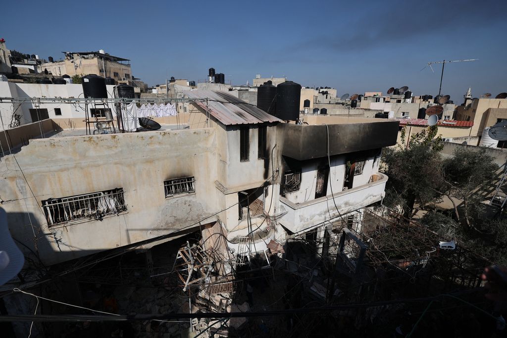 Sebuah bangunan hancur dan terbakar akibat serangan tentara Israel ke kamp pengungsi di kota Jenin, Tepi Barat, Kamis (26/1/2023). 