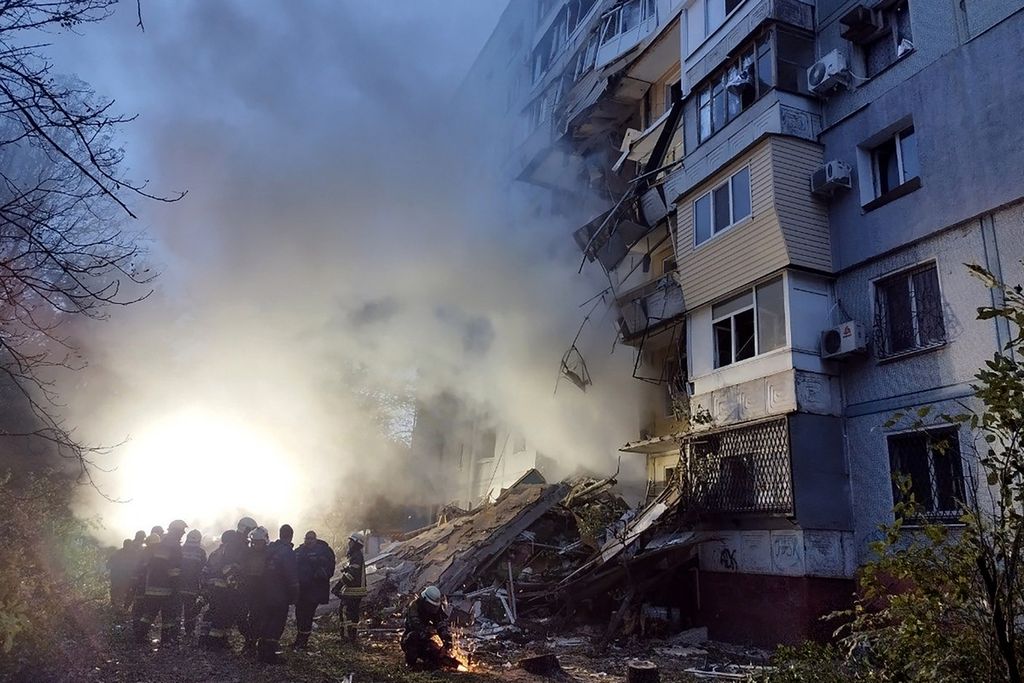 Anggota tim penyelamat bekerja di dekat sebuah apartemen permukiman setelah serangan di Zaporizhia, Ukraina, Minggu (9/10/2022). 