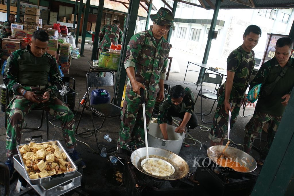 Anggota TNI memasak makanan untuk korban banjir dapur umum di lokasi pengungsian markas Komando Resor Militer (Korem) 131/Santiago di Manado, Sulawesi Utara, Sabtu (28/1/2023). Sehari sebelumnya, Manado dilanda banjir dan tanah longsor yang menewaskan sedikitnya lima orang.