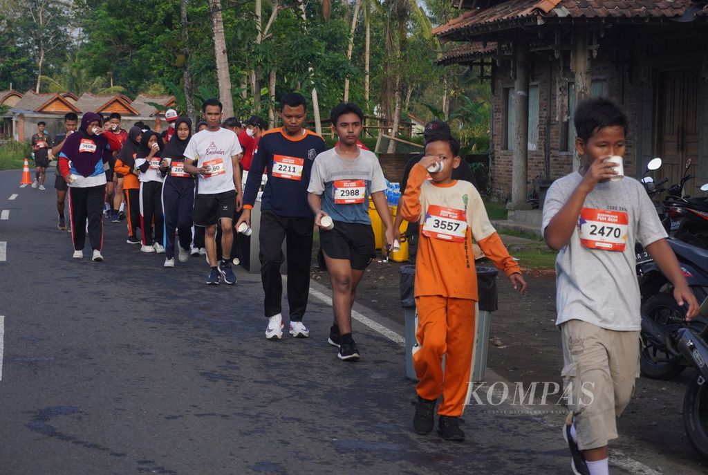 Peserta Borobudur Fun Run menikmati air minum dan air isotonik yang disediakan panitia di Desa Borobudur, Kecamatan Borobudur, Kabupaten Magelang, Jawa Tengah, Sabtu (3/12/2023). 