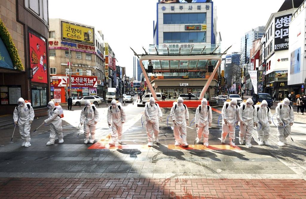 Militer Korea Selatan yang menggunakan alat pelindung diri menyemprotkan disinfektan untuk mencegah penyebaran Covid-19 di jalanan kota Daegu, Korea Selatan, 27 Februari 2020.