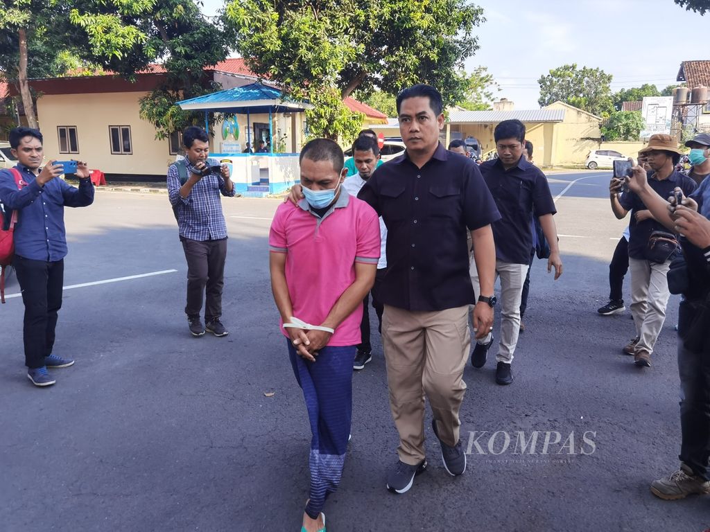 Tersangka LM (tangan diborgol) dibawa anggota Polda NTB menuju tempat konferensi pers di kantor Polda NTB di Mataram, Selasa (23/5/2023). LM ditangkap karena kasus dugaan kekerasan seksual yang dilakukan terhadap penghuni asrama yang dikelolanya di Lombok Timur.