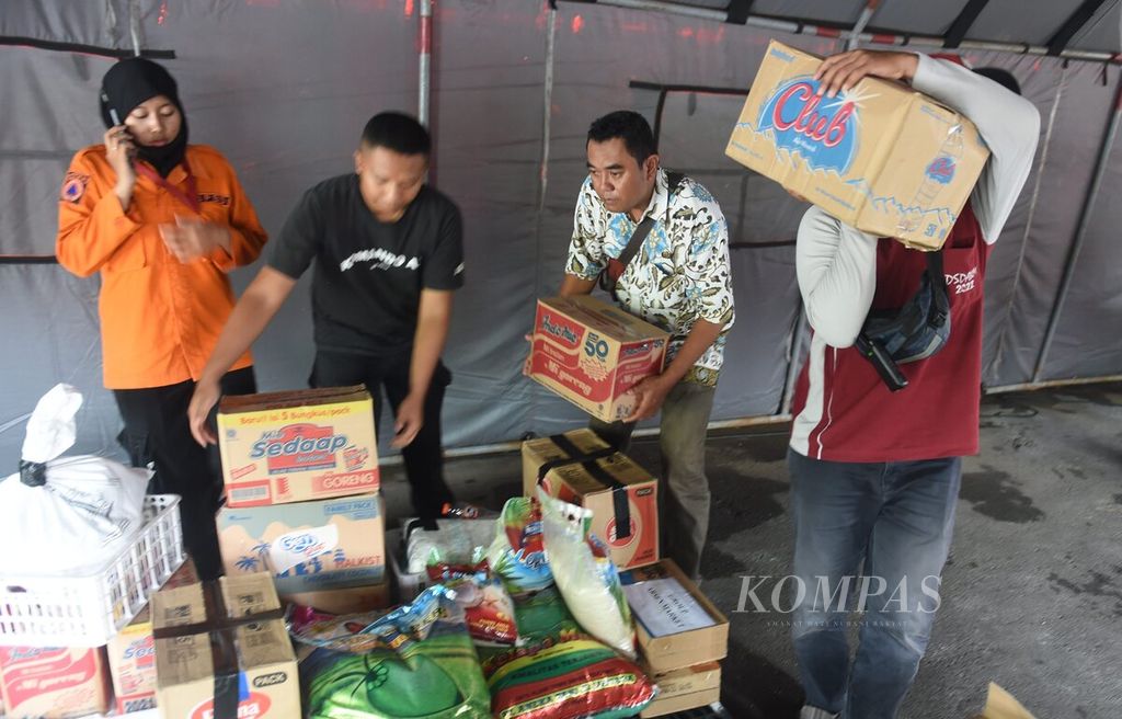Petugas membawa paket bantuan dari warga untuk dimasukkan ke atas truk bersama paket sembako dari Pemkot Surabaya yang akan dikirim bagi korban gempa bumi Cianjur di Posko Bangga Surabaya Peduli di Balaikota Surabaya, Jawa Timur. Kamis (24/11/2022). 