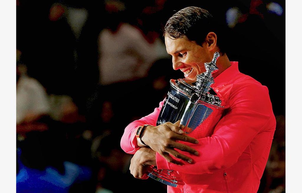   Senyum juara petenis Spanyol, Rafael Nadal, yang memeluk trofi Grand Slam Amerika Serikat Terbuka setelah menang 6-3, 6-3, 6-4 atas petenis Afrika Selatan, Kevin Anderson, pada final tunggal putra di Stadion Arthur Ashe, New York, Minggu (10/9). Ini merupakan gelar ke-16 Nadal di ajang Grand Slam.
