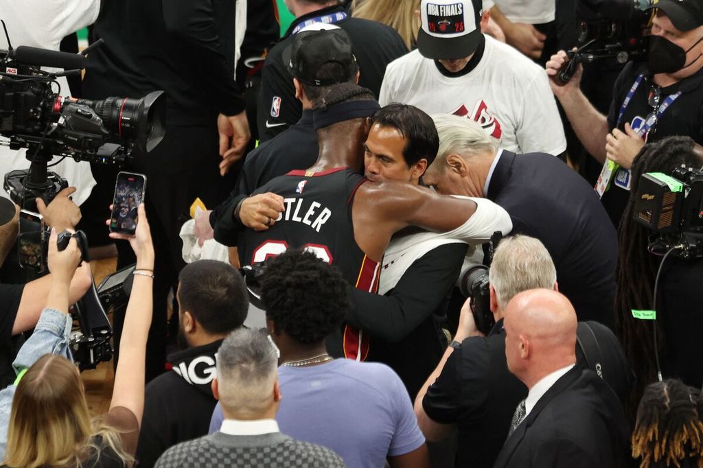 Bintang Miami Heat, Jimmy Butler (tengah), memeluk pelatihnya, Erik Spoelstra, setelah mengalahkan tuan rumah Boston Celtics pada gim ketujuh final Wilayah Timur NBA di TD Garden, Boston, Amerika Serikat, Selasa (30/5/2023). Heat menang, 103-84, dan lolos ke final NBA dengan keunggulan 4-3 di final wilayah.