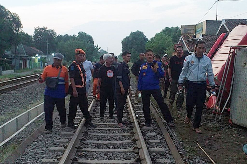 Petugas mengecek mobil pemadam kebakaran yang rusak parah setelah terlibat kecelakaan dengan kereta api barang di pelintasan sebidang daerah Hauergeulis, Kabupaten Indramayu, Jawa Barat, Selasa (2/7/2024).