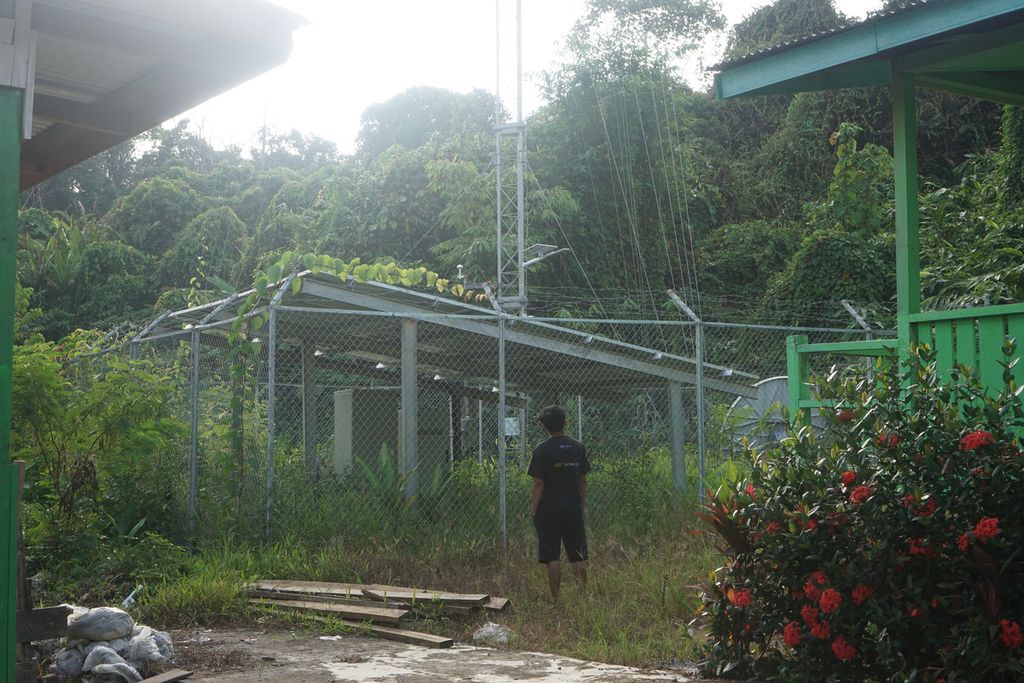 Seorang warga berdiri di sekitar menara BTS 4G di Desa Long Peleban, Kecamatan Peso, Kabupaten Bulungan, Kalimantan Utara, Senin (23/10/2023). Menara yang dibangun dari program Bakti Kementerian Kominfo itu hanya bisa digunakan dua hari dan setelahnya tak bisa digunakan sama sekali.