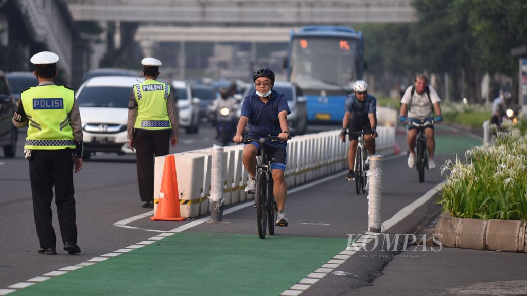 Petugas kepolisian berjaga di jalur sepeda di Jalan Jenderal Sudirman, Jakarta, Rabu (2/6/2021). Hari itu petugas dari kepolisian dan dinas perhubungan meminta pesepeda melaju di jalur sepeda.