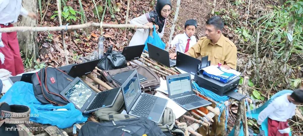 Sejumlah siswa sekolah dasar harus masuk ke dalam hutan dan memanjat bukit untuk mengikuti asesmen nasional berbasis komputer (ANBK) di Desa Mentuda, Kecamatan Lingga, Kabupaten Lingga, Kepulauan Riau, Selasa (25/10/2022).