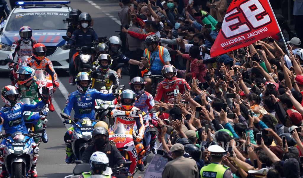 Warga menyambut sejumlah pebalap MotoGP yang beriring melintasi Jalan MH Thamrin, Jakarta, Rabu (16/3/2022). Para pebalap yang akan berlaga di ajang MotoGP Sirkuit Mandalika, Nusa Tenggara Barat, melakukan iring-iringan setelah menemui Presiden Joko Widodo di Istana Merdeka. Iring-iringan para bintang aspal” ini menempuh rute Istana Merdeka hingga Hotel Indonesia Kempinski dan disambut meriah oleh sejumlah warga yang menanti di sepanjang jalan tersebut. Mulai Jumat (18/3/2022) hingga Minggu (20/3/2022), mereka akan memulai rangkaian perhelatan ajang MotoGP di Sirkuit Internasional Jalan Raya Pertamina Mandalika, Nusa Tenggara Barat. 
