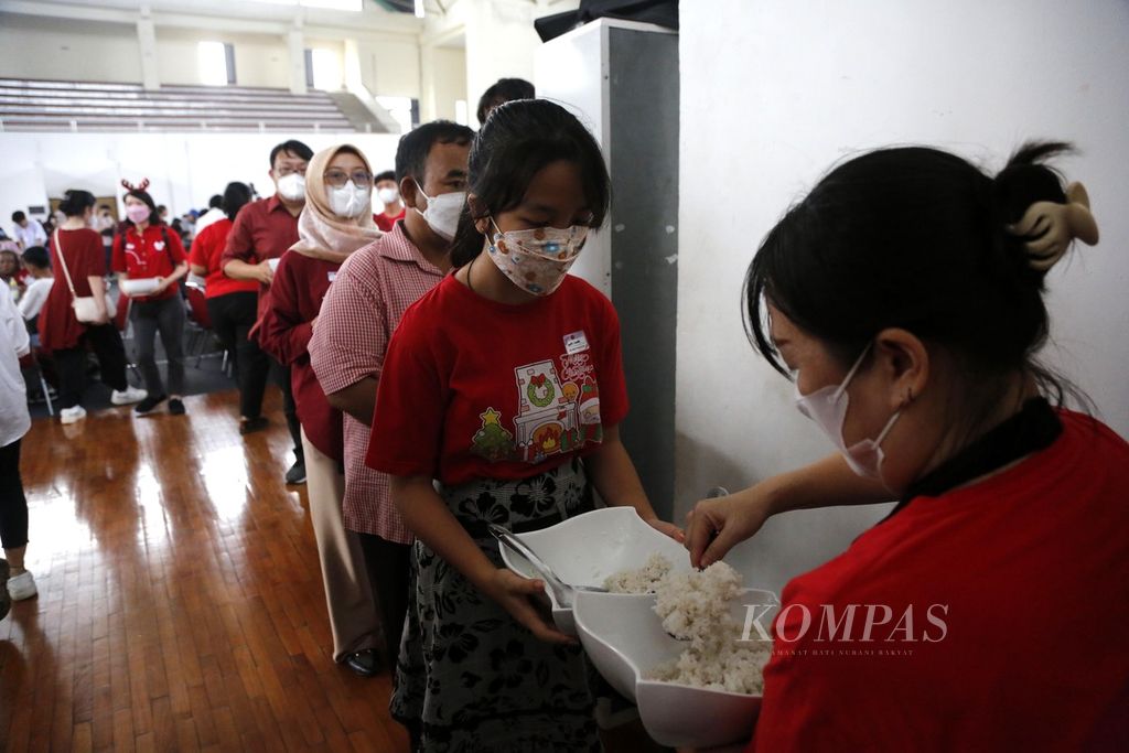 Para sukarelawan dari Komunitas Domus Cordis melayani peserta Makan Siang Natal di Gedung Judo, Kelapa Gading, Jakarta Utara, Senin (25/12/2023). 