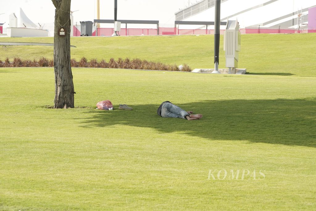 Pekerja beristirahat di bawah bayangan pohon, di kawasan Stadion Al Bayt, Al Khor, Qatar, Rabu (16-11-2022). 