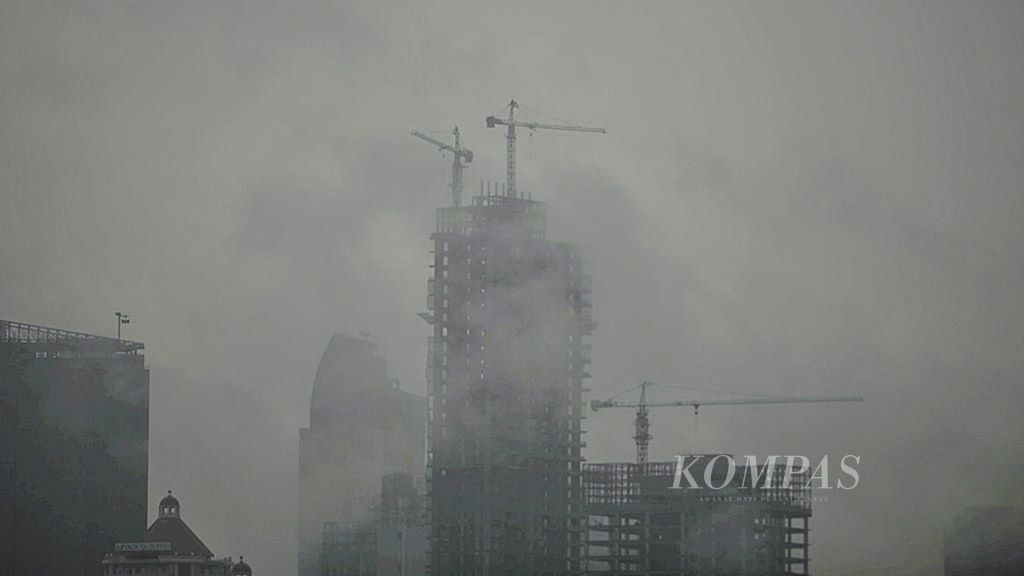  Kabut tipis menyelimuti proyek pembangunan apartemen di kawasan selatan Jakarta, Selasa (21/2).