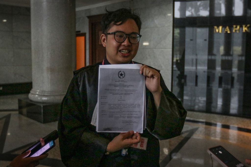 Zico Leonard Djagardo Simanjuntak menunjukkan salinan Keppres Nomor 114/P Tahun 2022 kepada wartawan di Gedung Mahkamah Konstitusi, Jakarta, Rabu (1/3/2023). Zico memberikan bukti baru terkait dugaan pengubahan substansi putusan MK berupa surat pemberhentian dengan hormat Hakim Konstitusi Aswanto yang tertuang dalam Keppres Nomor 114/P Tahun 2022. 