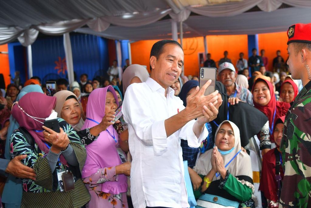Presiden Joko Widodo berfoto bersama warga penerima bantuan sosial. Sebelumnya, Presiden membagikan bantuan pangan cadangan beras pemerintah sebanyak 10 kilogram beras kepada warga penerima manfaat Program Keluarga Harapan di Gudang Bulog Gadang, Kota Malang, Jawa Timur, Kamis (14/12/2023).