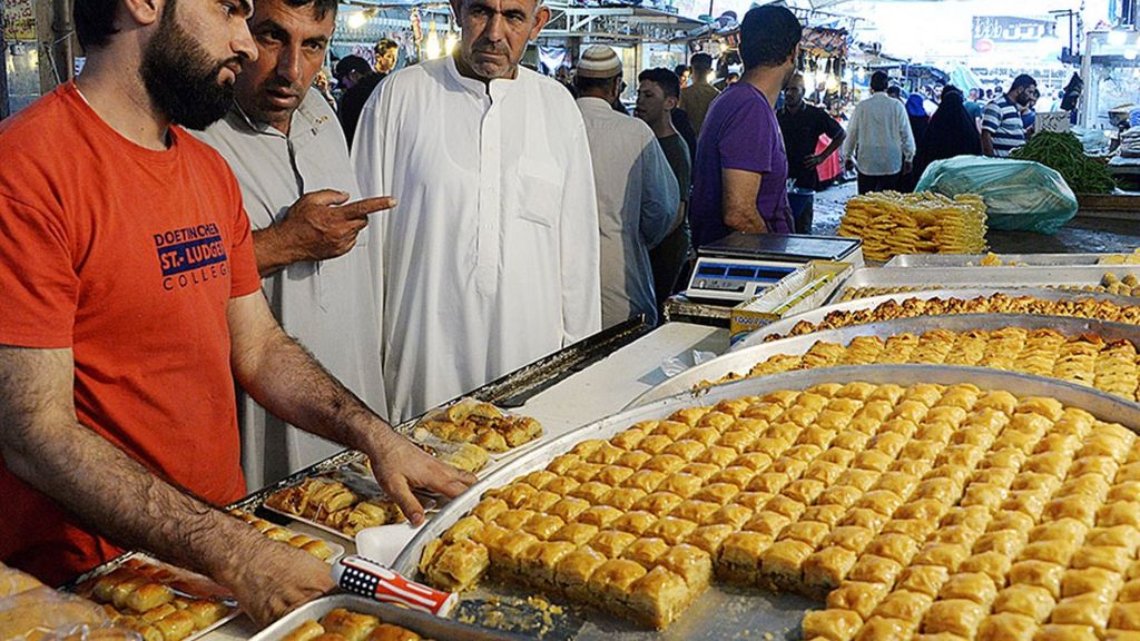 Warga Irak membeli makanan di sebuah pasar terbuka setelah buka puasa di Mosul, Irak, 24 Mei 2018. Kelompok Negara Islam di Irak dan Suriah (NIIS), yang pernah menguasai kota itu selama tiga tahun, melarang tradisi memukul tambur dan tradisi-tradisi lain untuk menandai bulan puasa di kota tersebut.