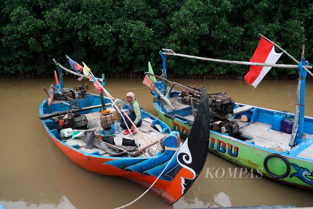 Nelayan di atas perahunya dengan latar belakang kawasan mangrove yang masih tersisa di Pantai Mangunharjo, Kecamatan Tugu, Kota Semarang, Jawa Tengah, Selasa (30/1/2024).  
