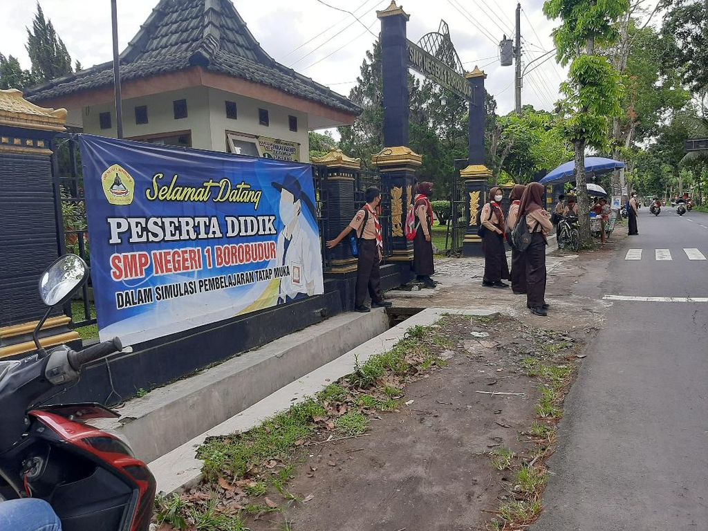 Sejumlah siswa peserta pembelajaran tatap muka (PTM) di SMP Negeri 1 Borobudur menunggu dijemput keluarga masing-masing di depan pagar sekolah, Jumat (11/3/2022). Selama pandemi, para siswa dilarang untuk berangkat dan pulang sekolah dengan menggunakan angkutan umum.