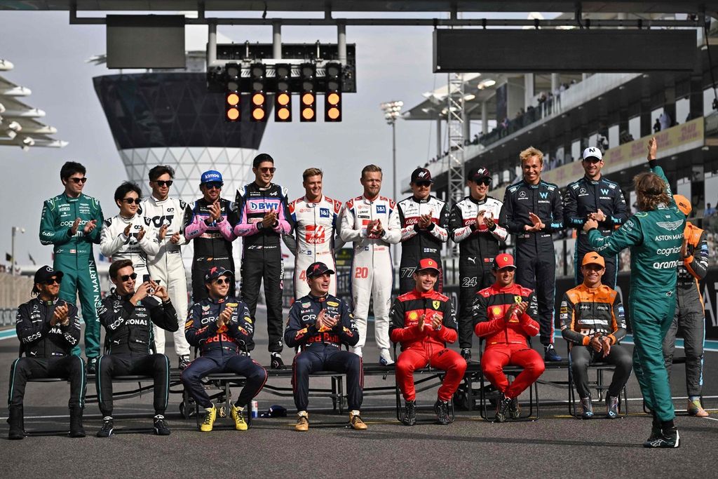 Pebalap senior Aston Martin, Sebastian Vettel (kanan), disambut meriah rekan-rekannya saat sesi foto bersama jelang balapan terakhir Vettel, di Grand Prix Formula 1 Abu Dhabi, di Sirkuit Yas Marina, Uni Emirat Arab, Minggu (20/11/2022).