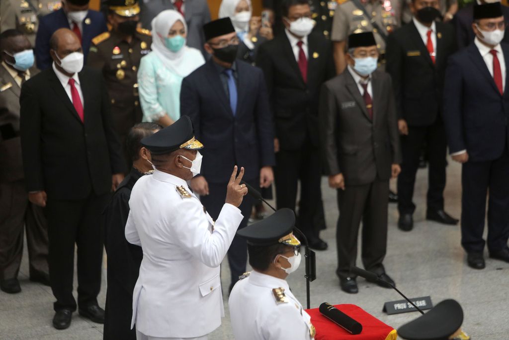 Komjen (Purn) Paulus Waterpauw (mengacungkan dua jari) saat mengucapkan sumpah dan janji jabatan dalam pelantikannya menjadi Penjabat Gubernur Papua Barat di Kantor Kementerian Dalam Negeri, Jakarta, Kamis (12/5/2022). Selain Paulus Waterpauw, ada empat penjabat yang dilantik bersamaan, yaitu Al Muktabar (Banten), Ridwan Djamaluddin (Bangka Belitung), Akmal Malik (Sulawesi Barat), dan Hamka Hendra Noer (Gorontalo). Para penjabat gubernur ini akan bertugas selam satu tahun. Mereka bisa kembali dipilih menjadi penjabat berikutnya atau diganti yang lain sampai dengan dilantiknya kepala daerah definitif hasil pilkada serentak yang diselenggarakan 27 November 2024.