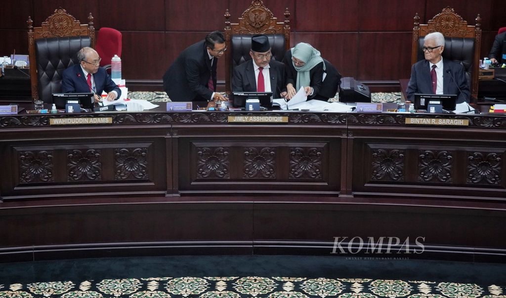 Petugas panitera sidang membantu menyiapkan berkas putusan untuk dibacakan pemimpin sidang Majelis Kehormatan Mahkamah Konstitusi, Jimly Asshiddiqie (tengah), dalam Sidang Putusan Etik yang digelar Majelis Kehormatan Mahkamah Konstitusi (MKMK) di Gedung Mahkamah Konstitusi, Jakarta, Selasa (7/11/2023). MKMK memutuskan untuk mencopot jabatan Anwar Usman sebagai Ketua Mahkamah Konstitusi. 