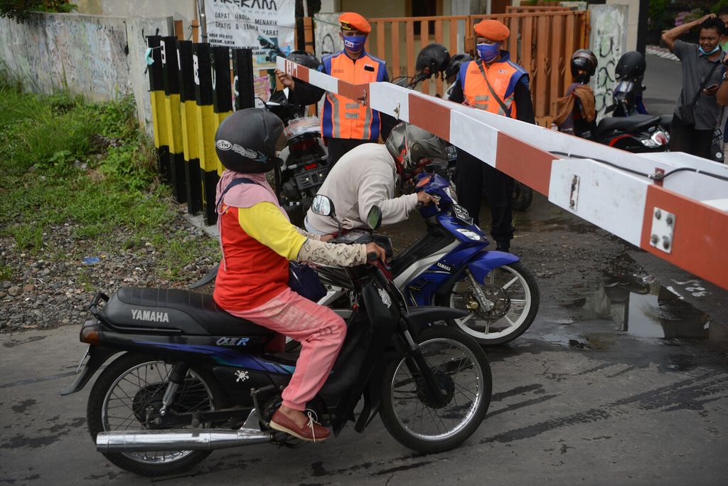 Pengguna sepeda motor berusaha melewati palang kereta api saat kegiatan sosialisasi keamanan berkendara di pelintasan sebidang sebelah barat Stasiun Klaten, Kabupaten Klaten, Jawa Tengah, Jumat (4/12/2020). 